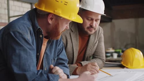 Two Male Architects Discussing Building Plan