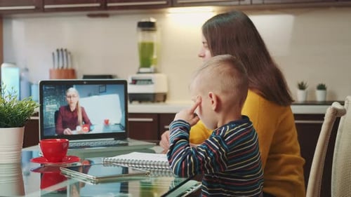 Woman and Child Video Call on Laptop in Kitchen