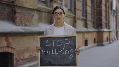 Beautiful Young Woman Standing Looking Down at Camera and Protest Against Bullying