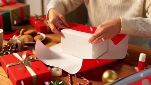 Woman Wrapping Christmas Gift on Wooden Table
