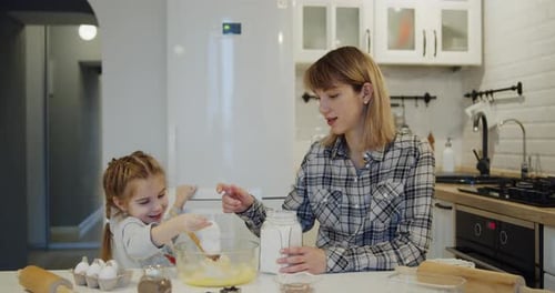 Mother and Daughter Baking Together in Kitchen