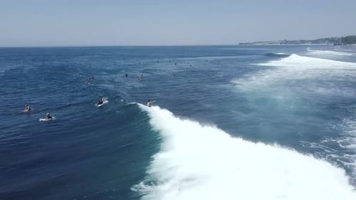 Aerial Tracking Shot of Male Surfer Riding a Big Wave Surfing in Ocean on Summer