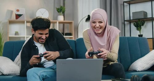 Couple Laughing and Playing Video Games at Home