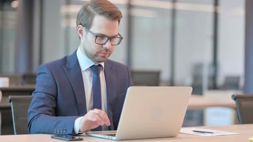 Professional Man Excited by Laptop in Office