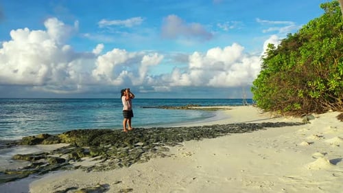 Sexy smiling girl on photoshoot having fun at the beach on paradise white sand and blue background 4