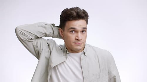 Young Puzzled Guy Scratching His Head and Crossing Hands Expressing Knowledge and Unguilty White