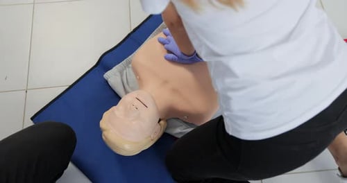 Woman Practices CPR on Medical Training Mannequin