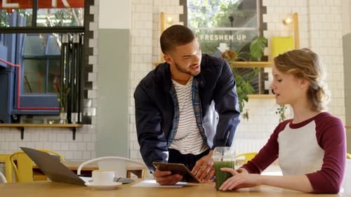 Executives discussing over a digital tablet in office cafeteria 4k