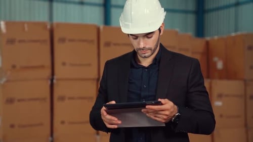 Factory Manager Using Tablet Computer in Warehouse or Factory