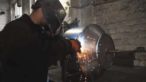 Worker in Protective Mask Welding Metal Construction at Metalworking Factory