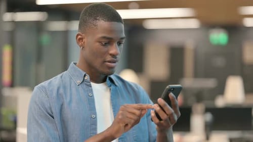 Young Adult Celebrates Success Using Mobile Phone