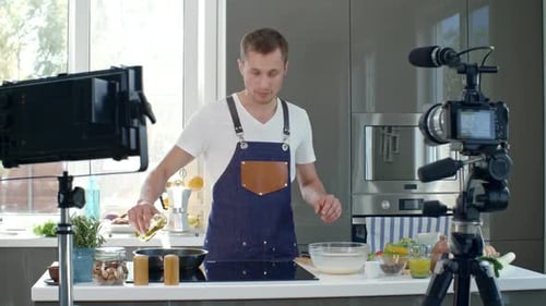 Man Filming Himself Cooking in Bright Kitchen