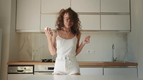Woman Joyfully Dancing in her Kitchen