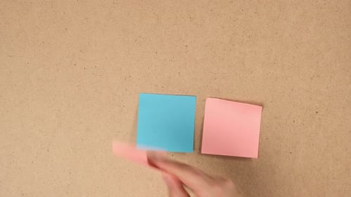 female hand gluing blank square multicolored stickers