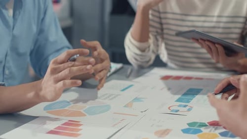 Business Team Collaborating on Charts in Office