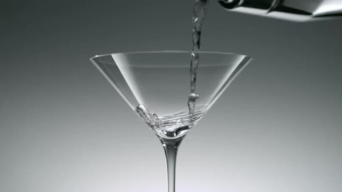 Clear Liquid Being Poured into Martini Glass
