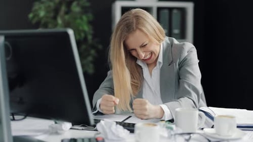 Businesswoman Celebrating Success at Office Desk
