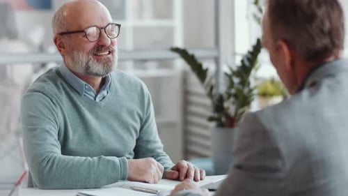 Joyous Senior Man Talking with Business Partner at Office Table