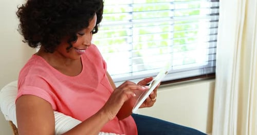 Woman using digital tablet in living room 4k