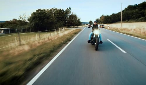 Man Riding Motorcycle Down Country Road
