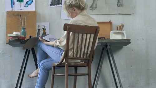 Blonde Haired Artist Drawing in a Studio