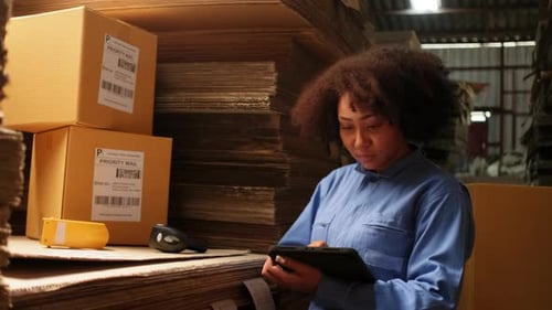 One female worker scan bar codes to check orders at parcels warehouse factory.