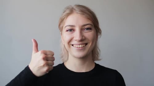 Smiling Blonde Woman Giving Thumbs Up
