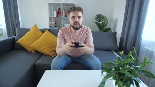 Young Adult Man Playing Video Game at Home