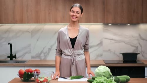 Smiling Woman Preparing Fresh Salad in Modern Kitchen