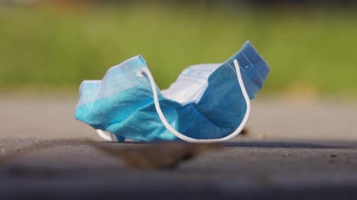 Protective Medical Mask Used and Thrown Away on City Street. Ecological Problem After Pandemic of