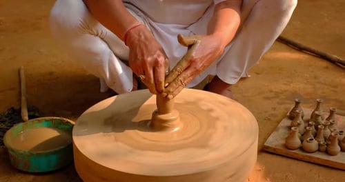 Des mains habiles de potier façonnent l'argile sur Potter Wheel et sculptent un pot en argile. Shipagramme