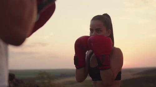 Woman Boxing Training in Field at Sunset