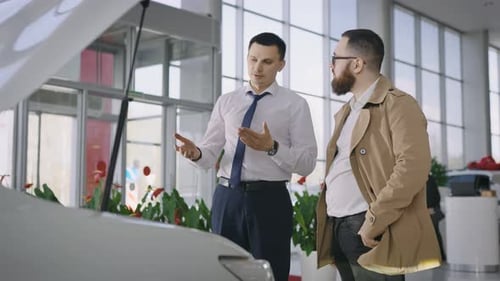 Sales Manager and Client Near a New Car with an Open Hood