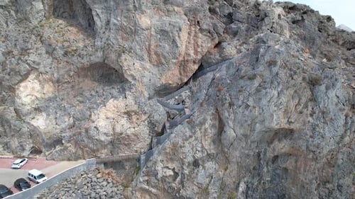 Drone flies over the stairs in the rock in Kalypso beach. Volcanic archipelago.