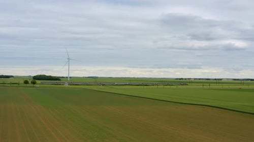 Train, railway in the meadow, windmills in the distance