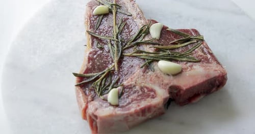 Steak frais T-Bone ou Porterhouse vieilli à sec sur planche à découper en marbre. Mariner dans de l'huile d'olive