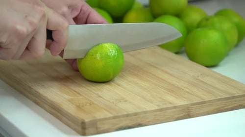 Lime Being Cut on Wooden Cutting Board