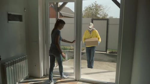 Woman Receives Package From Delivery Person at Door