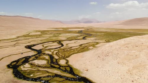 Top Aerial View of a Nearly Dry River Crossing Desert in Tajikistan Blue Sky in Background