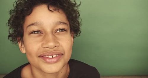 Cool boy smiling on a green background
