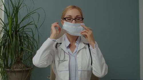 Woman Doctor Putting on a Surgical Mask