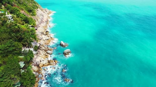 Beautiful coastline of tropical island with palm trees green vegetation and cliffs washed by calm tu