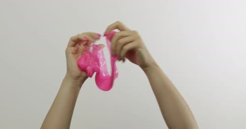 Woman Hands Playing Oddly Satisfying Pink Slime on White Background. Antistress