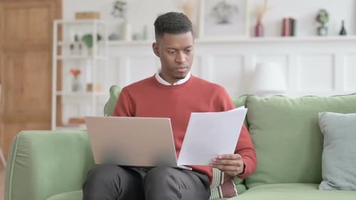 Man Working from Home with Laptop and Documents