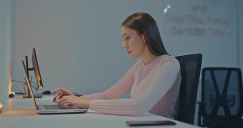 Portrait a Beautiful Woman is Typing on a Laptop at the Workplace in a Business Company