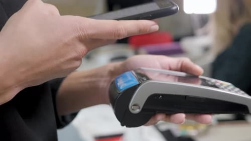 Customer Paying a Merchant with Mobile Phone with NFC Technology. Close Up Smartphone Payment.
