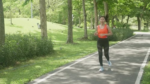 Beautiful young asian woman workout with jogging or running on summer in the park.