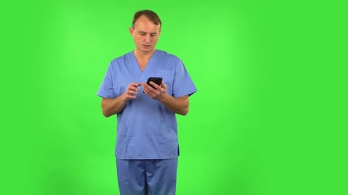 Medical Man Angrily Texting on Him Phone. Green Screen