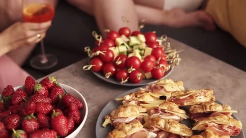 Young Women Celebrating with Drinks and Snacks