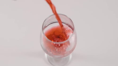 Pouring a Red Drink into Glass
